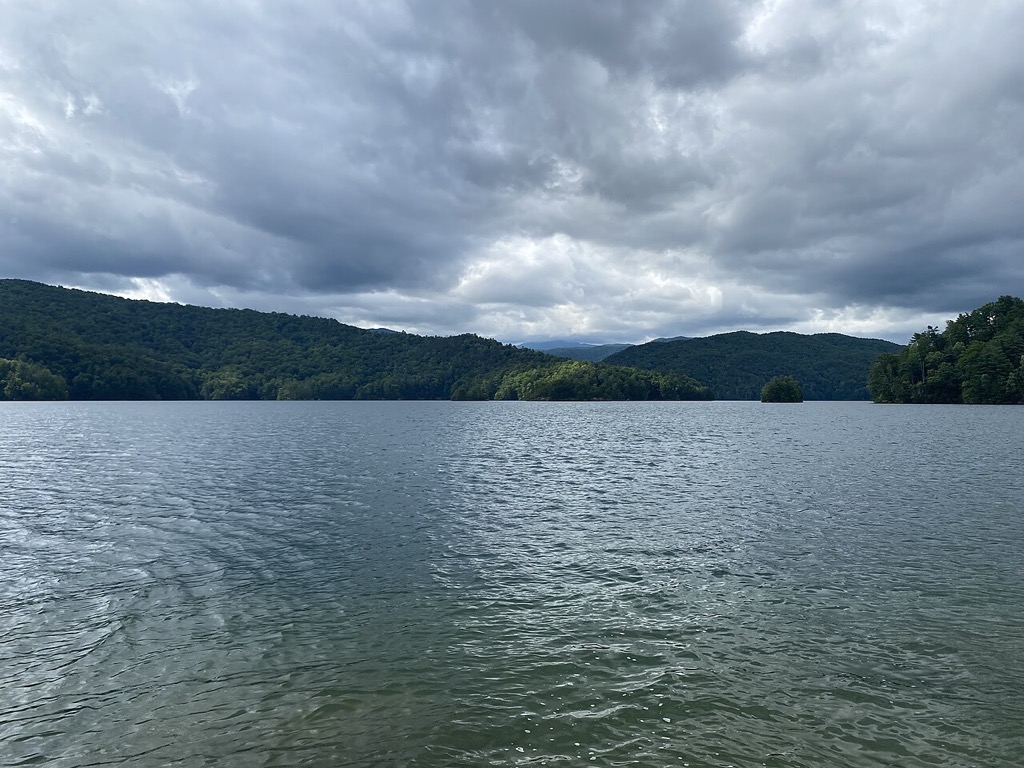 Lake Jocassee water beneath forested mountains and storm clouds